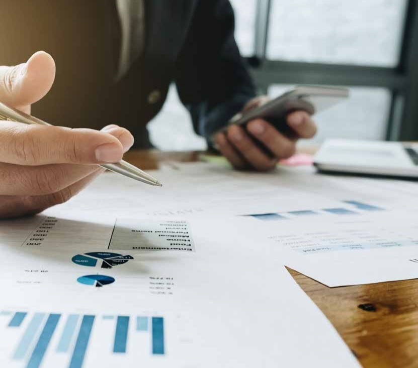 Mano che indica grafici e bilancio condominiale durante una riunione